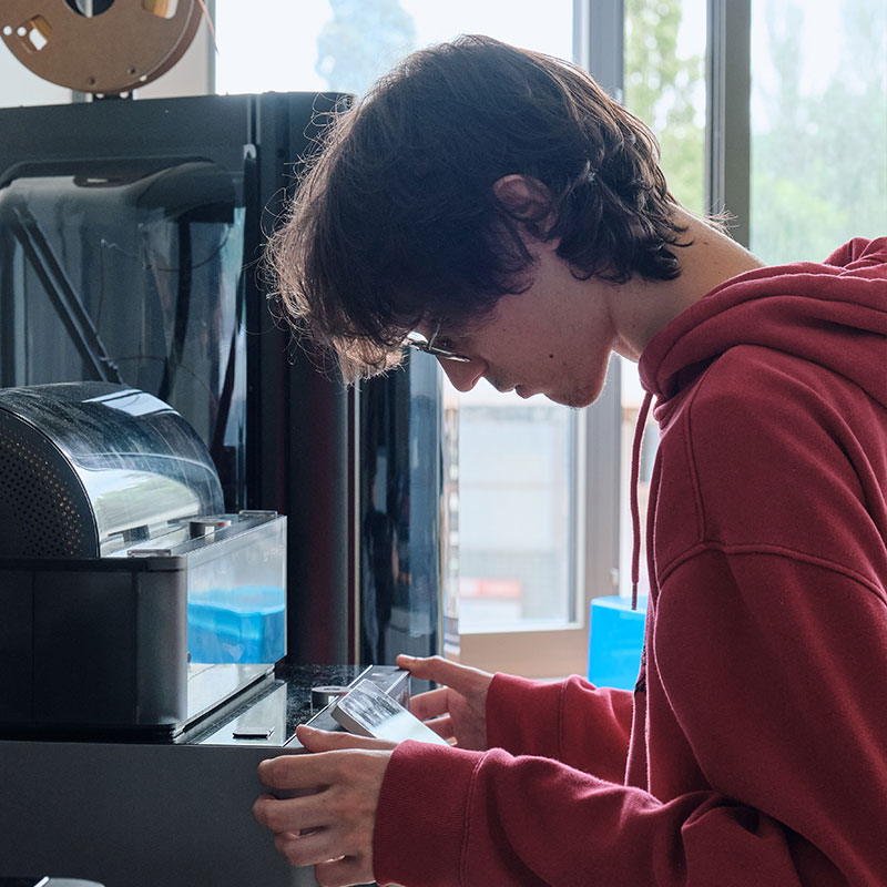 Étudiant manipulant une imprimante 3D